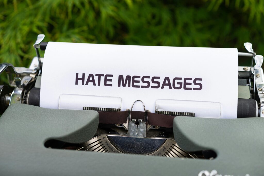 Close-up of a vintage typewriter with paper displaying 'Hate Messages', exploring themes of communication and negativity.